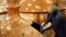 FILE - Workers pour brewing ingredients in a copper kettle at the Nile Brewery Company, east of Uganda's capital Kampala. In the slums of Kampala, friends gather to drink their cheap home made brew 'malwa'.