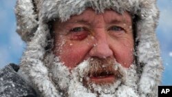 FILE - A worker pauses while removing snow from Highmark Stadium in Orchard Park, N.Y., Jan. 14, 2024. While the U.S. is shivering through bone-chilling cold, most of the rest of world is feeling unusually warm weather. (AP Photo/ Jeffrey T. Barnes, File)