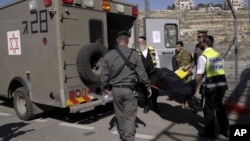 Israeli emergency services personnel carry the body of a Palestinian, identified as Naim Safi, at a checkpoint near Jerusalem, Feb. 14, 2016. 