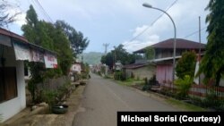 Warga mengibarkan bendera Merah Putih setengah tiang di depan rumah masing-masing tanda berduka cita atas meninggalnya Bupati Morowali Utara akibat virus corona di Kolonodale, Morowali Utara, 4 April 2020. (Foto: Michael Sorisi)