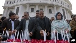 Pakistani lawmakers from provincial Khyber Pakhtunkhwa assembly light candle during a ceremony to mark second anniversary of a Taliban attack in 2014 on a school in Peshawar, Dec. 16, 2016.