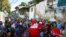 Un hombre disfrazado de Santa Claus, de la ONG "Santa en las calles", saluda a los vecinos antes de repartir alimentos y donar ropa, en un barrio de bajos recursos de Guarenas, al este de Caracas, Venezuela el 19 de diciembre de 2020.