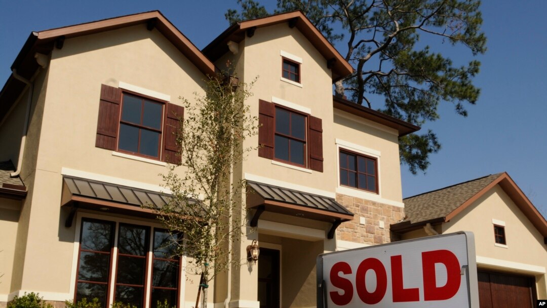 FILE - A sold sign sits outside a new home in Houston, Texas.