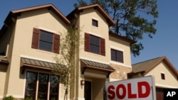 FILE - A sold sign sits outside a new home in Houston, Texas.