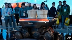 People view a demonstration of the KATR robot designed to work in agriculture and construction at the Kubota booth during the CES tech show Tuesday, Jan. 7, 2025, in Las Vegas. (AP Photo/John Locher)