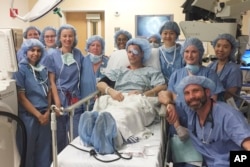 This photo provided by Mass Eye and Ear Phil Durst sits with the surgical team after the first transplant procedure in Boston in April 2018. (Mass Eye and Ear via AP)
