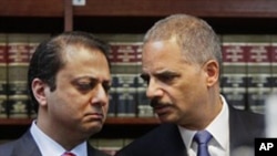 U.S. Attorney General Eric Holder, right, and U.S. Attorney for New York's Southern District Preet Bharara confer at a news conference in New York, 20 Jan 2011