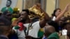 South Africa's Springboks captain Siya Kolisi holds the Webb Ellis trophy as fans welcome the team upon arrival at O.R Tambo International Airport in Johannesburg, South Africa, Oct. 31, 2023, after the Rugby World Cup.