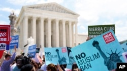 FILE - Protesters hold up signs outside the the Supreme Court in Washington, June 26, 2018.