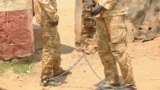 FILE - South Sudanese soldiers suspected of beating and raping civilians are chained together at the presidential guard unit, within the Sudan People's Liberation Army headquarters, after their arrest in Juba, March 3, 2017. 