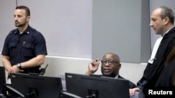 FILE - Former Ivory Coast President Laurent Gbagbo, center, and his lawyer Emmanuel Altit, right, wait for the start of the trial at the International Criminal Court in The Hague, Netherlands, Jan. 28, 2016. 