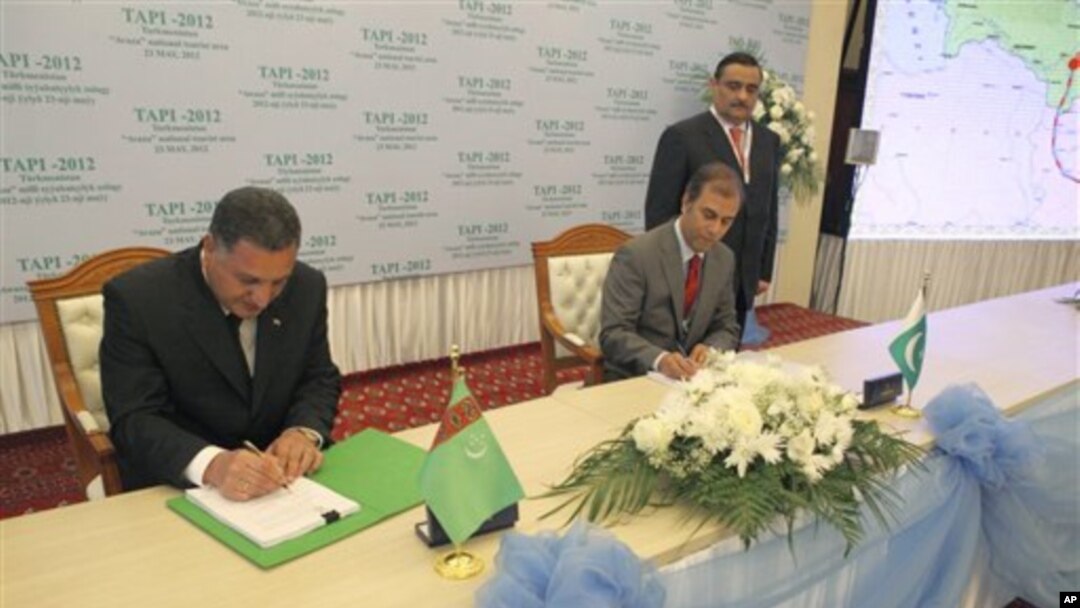 Kepala perusahaan energi Turkmenistan Sahatmurad Mamedov (kiri) dan perwakilan dari Pakistan Mobin Saulat menandatangani dokumen pembangunan jaringn pipa di Avaza, Turkmenistan (23/5)