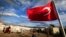 FILE -  A Turkish flag flies at the refugee camp for Syrian refugees in Islahiye, Gaziantep province, southeastern Turkey, March 16, 2016. 