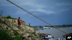 FILE - A boy climbs a hill near a low Amazon River due to the drought, in Leticia, Colombia, Oct. 20, 2024.