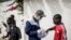 Un travailleur du Village Pilote distribue de l'eau et des sandwichs aux enfants des rues de Dakar, le 10 avril 2020, pendant le confinement.