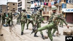 FILE - Kenyan police clear debris from a barricaded road after a protest by supporters of the National Super Alliance opposition coalition presidential candidate at Mathare slum in Nairobi, Aug. 11, 2017.