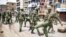 FILE - Kenyan police clear debris from a barricaded road after a protest by supporters of the National Super Alliance opposition coalition presidential candidate at Mathare slum in Nairobi, Aug. 11, 2017.