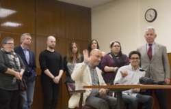 FILE - A juror raises his hand while speaking to the press at the state Supreme Court after the judge declared a mistrial in the case of slain missing child Etan Patz, New York, May 8, 2015.