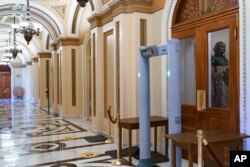 FILE - Members of the House of Representatives must now pass through a security check with metal detectors before entering the chamber, a new safety measure put into place after a mob stormed the Capitol January 6, in Washington, Jan. 27, 2021.