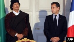 Le leader libyen Mouammar Kadhafi et le président français Nicolas Sarkozy posent lors de la signature de 10 milliards d'euros de contrats commerciaux, à Paris, le 10 décembre 2007.