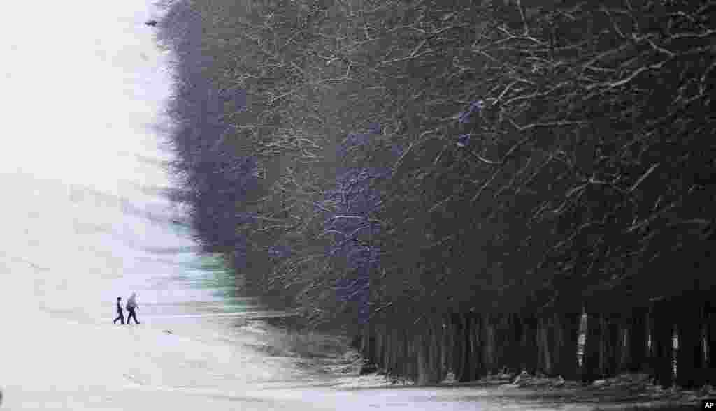 A couple walk through the snow at Stormont, Belfast, Northern Ireland.