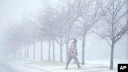 Una persona cruza una calle mientras cae una fuerte nevada el domingo 5 de enero de 2025 en St. Louis. (Foto AP/Jeff Roberson)