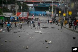 Orang-orang berlarian setelah bentrokan meletus selama protes kenaikan harga bahan bakar dan menuntut agar Perdana Menteri Haiti Ariel Henry mundur, di Port-au-Prince, Haiti, Jumat, 16 September 2022. (Foto: AP)