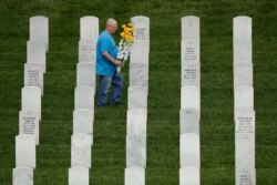A man looks for a grave while visiting Leavenworth National Cemetery, May 23, 2020 in Leavenworth, Kan.