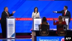 ARCHIVO - La exembajadora ante la ONU, Nikki Haley, observa mientras el gobernador de Florida, Ron DeSantis (Der) y el exgobernador de Nueva Jersey, Chris Christie (Izq), hablan en el cuarto debate de primarias republicanas, el 6 de diciembre de 2023 en Alabama.