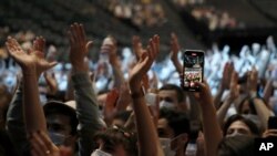 Thousands of people, masked and tested for the virus, pack inside a Paris concert hall as part of a public health experiment to prepare the country to host big events again, in Paris, Saturday, May 29, 2021.