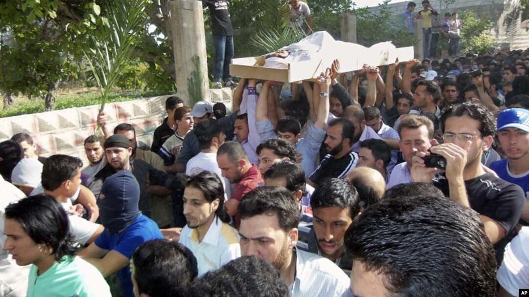Manifestantes antigubernamentales en Siria participan de los funerales de las víctimas en Dir el Zour.