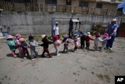 Children play during recess at a government-run daycare where they are fed one meal at lunch time in Catzuqui de Velasco, a rural area without reliable basic services like water and sewage, on the outskirts of Quito, Ecuador on December 1, 2022. (AP Photo/Dolores Ochoa)