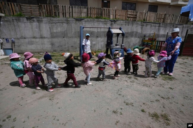 Children play during recess at a government-run daycare where they are fed one meal at lunch time in Catzuqui de Velasco, a rural area without reliable basic services like water and sewage, on the outskirts of Quito, Ecuador on December 1, 2022. (AP Photo/Dolores Ochoa)