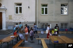 Ukrainian refugee children gather outside the Lauder Morasha Jewish school in Warsaw, Poland, Thursday, July 28, 2022. A special summer camp run by Jewish organizations has brought Jewish volunteers from the former Soviet Union to Warsaw to help Ukrainian children. (AP Photo/Michal Dyjuk)