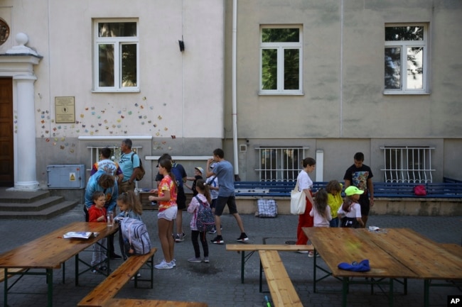 Ukrainian refugee children gather outside the Lauder Morasha Jewish school in Warsaw, Poland, Thursday, July 28, 2022. A special summer camp run by Jewish organizations has brought Jewish volunteers from the former Soviet Union to Warsaw to help Ukrainian children. (AP Photo/Michal Dyjuk)