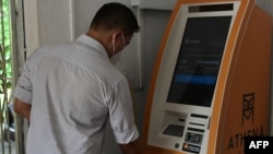 Seorang pria menggunakan ATM Bitcoin di El zonte, tenggara San Salvador, El Salvador (foto: ilustrasi). 
