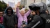 A woman shouts at police during a protest in front of the prosecutor's office following the disappearance in Guayaquil of four children who were last seen running away from a military convoy, in Quito, Ecuador, Dec. 23, 2024.