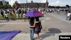 A gay couple look on as thousands of Catholics and conservatives gathered together against the legalization of gay marriage and to defend their interpretation of traditional family values in Monterrey City, Mexico September 10, 2016.