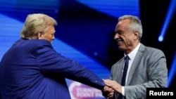 Robert F. Kennedy Jr. (kanan) menyapa Donald Trump dalam sebuah acara kampanye di Duluth, Georgia, pada 23 Oktober 2024. (Foto: Reuters/Carlos Barria)