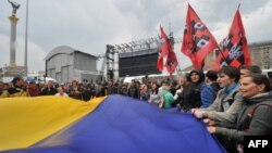 Protesters wave a giant Ukrainian flag during a protest rally in Kiev on June 5, 2012.