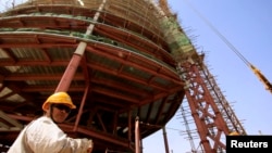 FILE - A building rises behind a Chinese engineer on the skyline of Khartoum, the capital of Sudan, in 2009. 