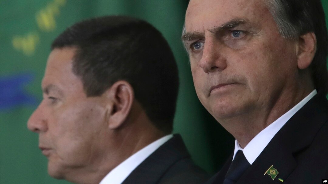 While Brazil's President Jair Bolsonaro was attending the World Economic Forum, Jan. 23, 2019, Vice President Hamilton Mourao, left, signed the decree expanding exceptions within the 2011 transparency law.