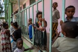Children displaced by the conflict play on metal railings at the elementary school where they now live with their families in the town of Abi Adi, in the Tigray region of northern Ethiopia, May 11, 2021.