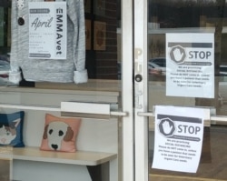 A sign on the door at emergency veterinarian EMMAvet requests social distancing from customers. (Deborah Block/VOA)