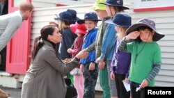 Prince Harry, Duke of Sussex, with Meghan Markle, Duchess of Sussex, meet schoolboy Joe Young, right, and other children outside the Maranui Cafe in Wellington, New Zealand, Oct. 29, 2018.