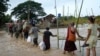 Local residents wade through flooded water at a broken bridge, in Naypyitaw, Myanmar, Sept. 17, 2024. 