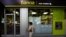 woman walks by an ATM cash machine at a branch of the Bankia bank in Madrid, June 6, 2012.
