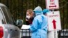 Medical personnel from Montgomery County, Md., check patients arriving for a COVID-19 drive-in testing in Silver Spring, April 21, 2020. 