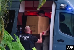 FILE - Agen Investigasi Keamanan Dalam Negeri memasukkan sebuah kotak ke dalam mobil di pintu masuk rumah produser dan musisi AS Sean "Diddy" Combs di Star Island di Miami Beach, 25 Maret 2024. (GIORGIO VIERA / AFP)