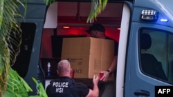 (ARCHIVOS) Agentes de la Investigación de Seguridad Nacional cargan una caja en un automóvil en la entrada de la casa del productor y músico estadounidense Sean "Diddy" Combs en Star Island en Miami Beach el 25 de marzo de 2024.